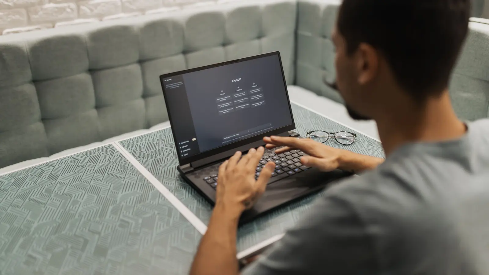 A person working on a laptop with an AI chat assistant open