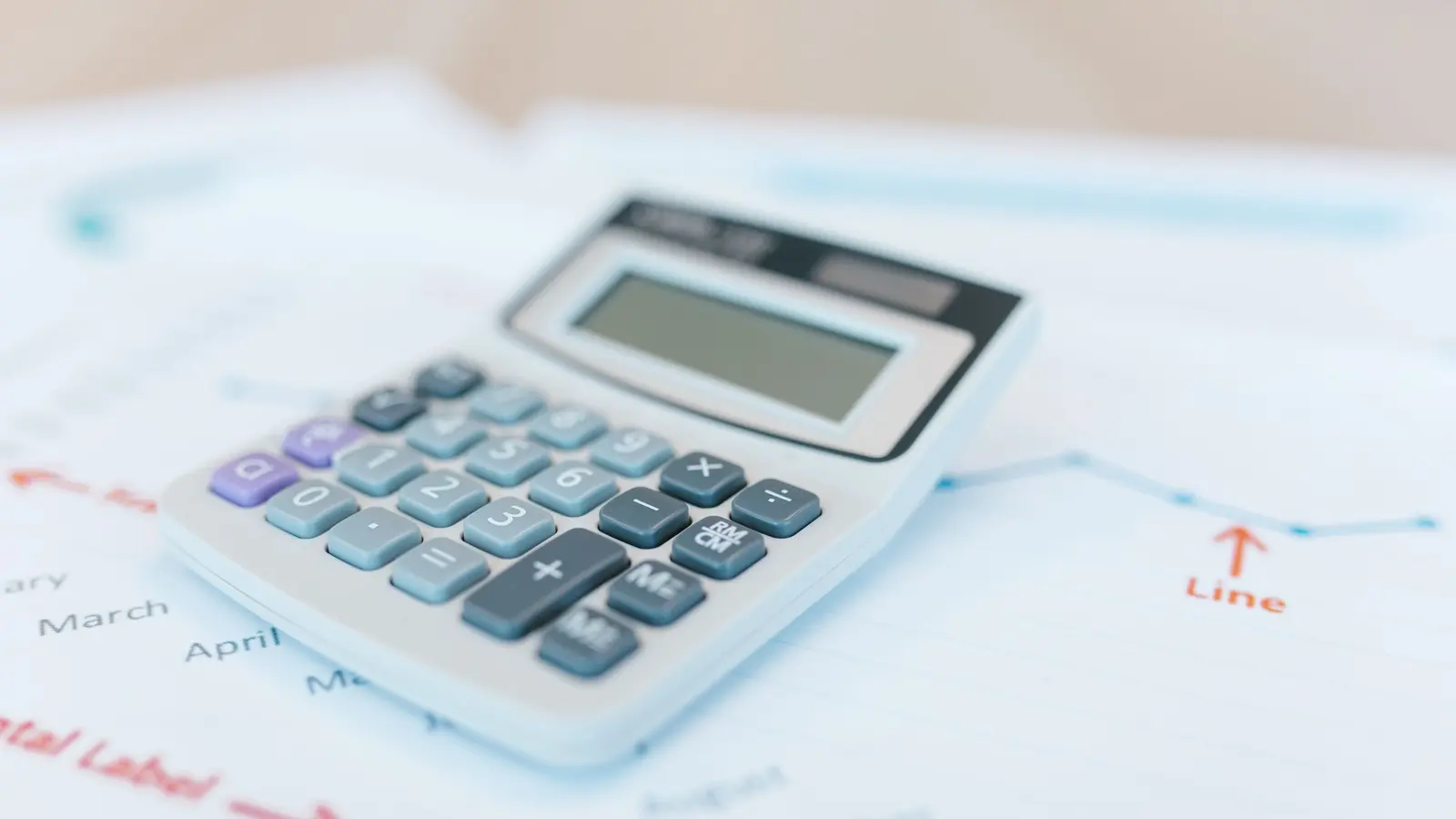 A calculator and budget spreadsheet on a desk