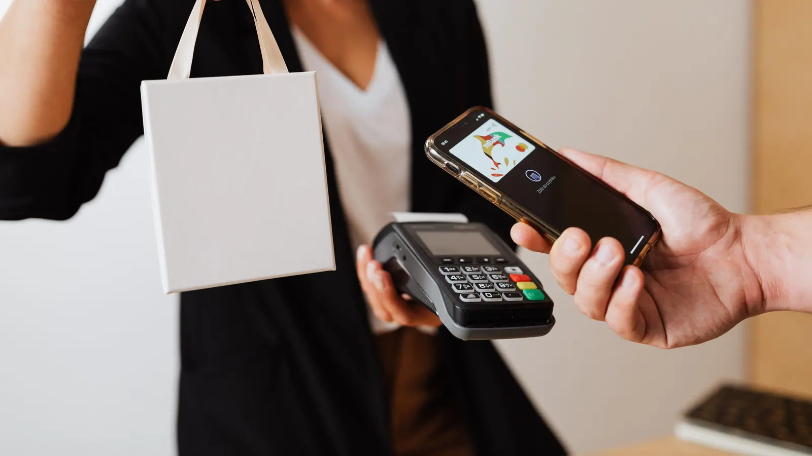 A customer paying by phone at a contactless terminal
