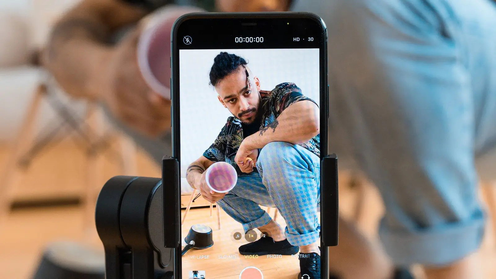 A man recording video content with a smartphone on a tripod