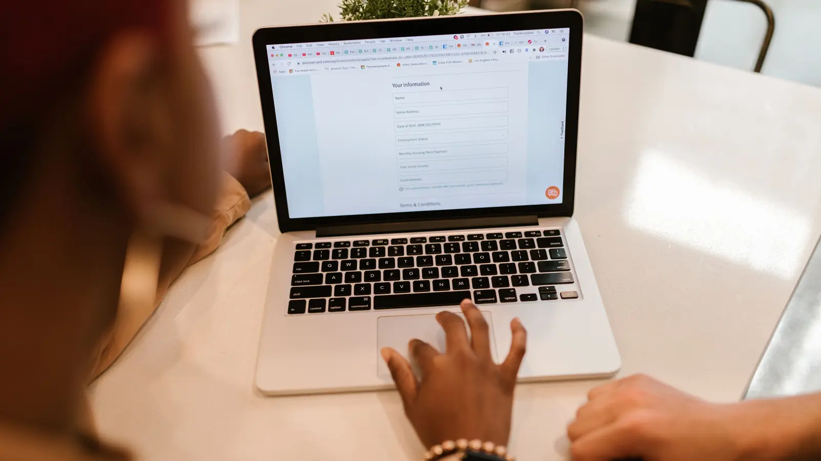 Two people completing an online form on a laptop