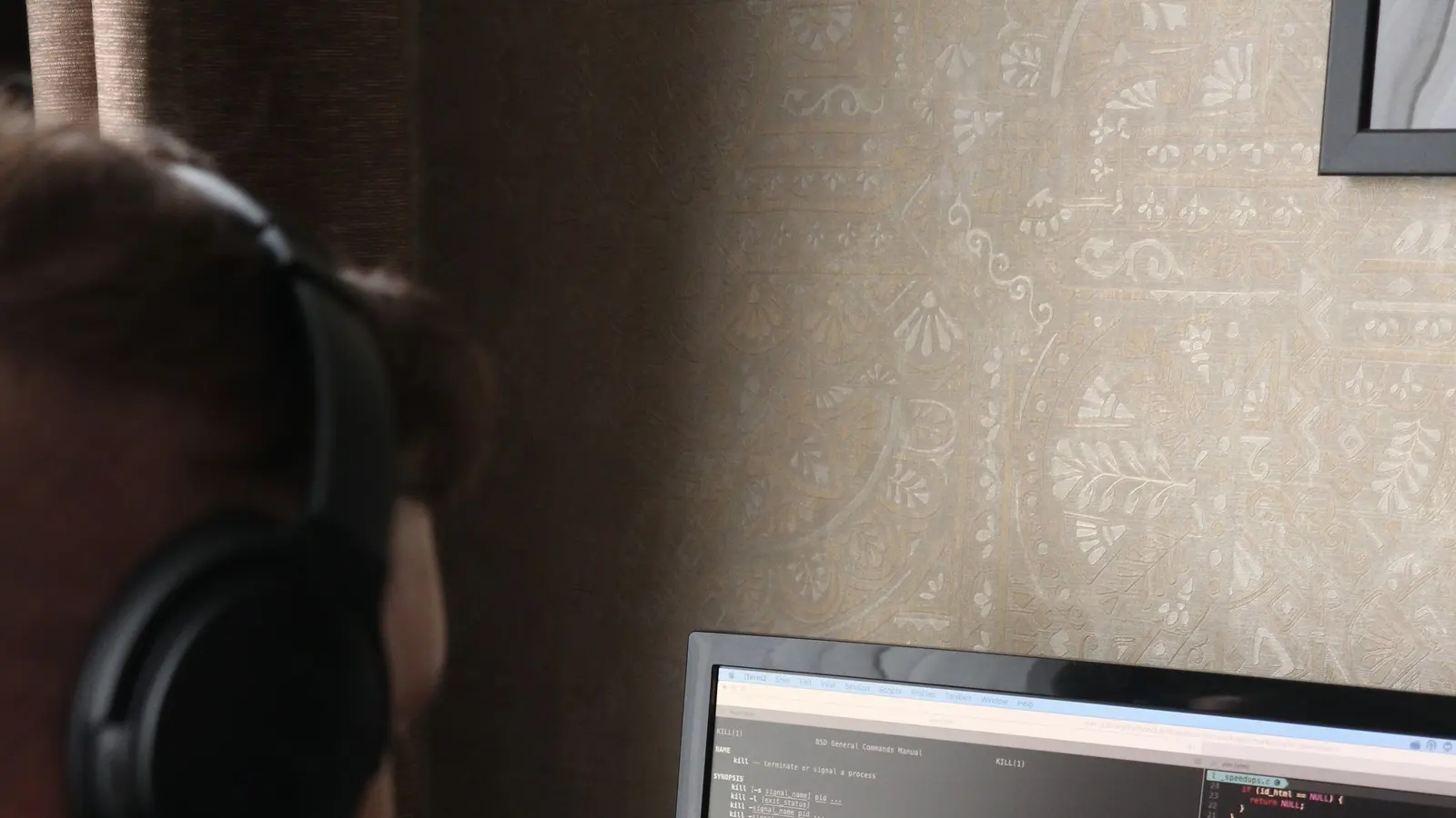 A developer writing application code across two monitors