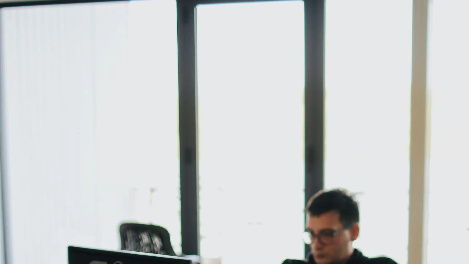 A web developer working across multiple screens in an office