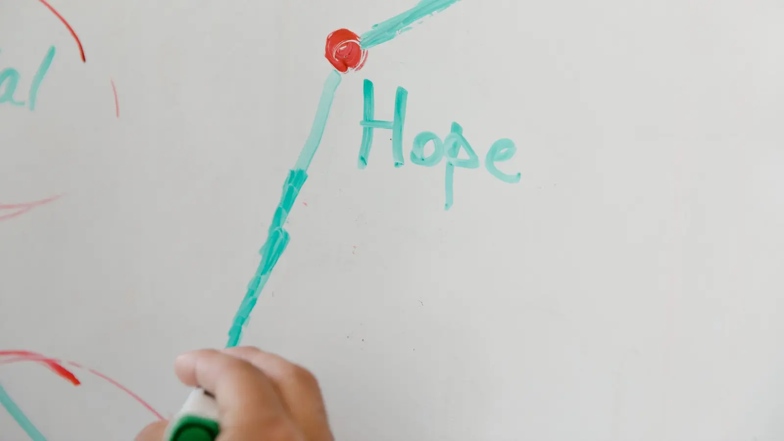 A hand drawing a diagram on a whiteboard