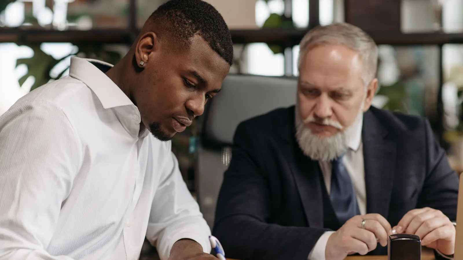Two professionals reviewing paperwork together in an office