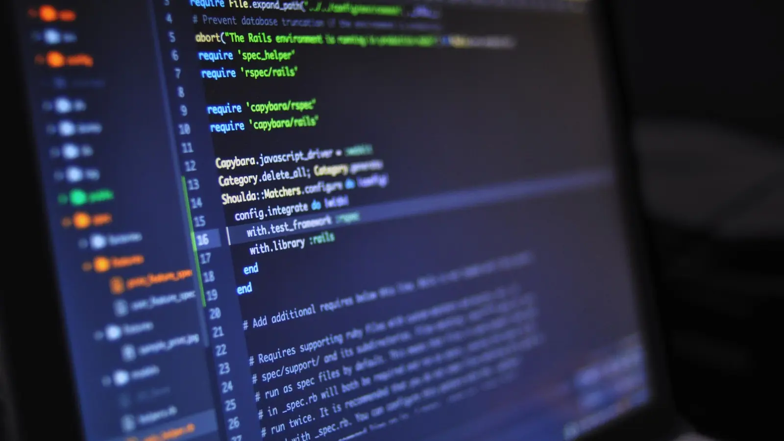 Programming code displayed on a screen in a dark room