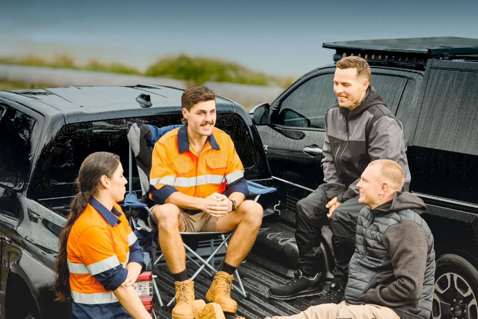 Four workers in Portwest workwear talking on the tray of a ute